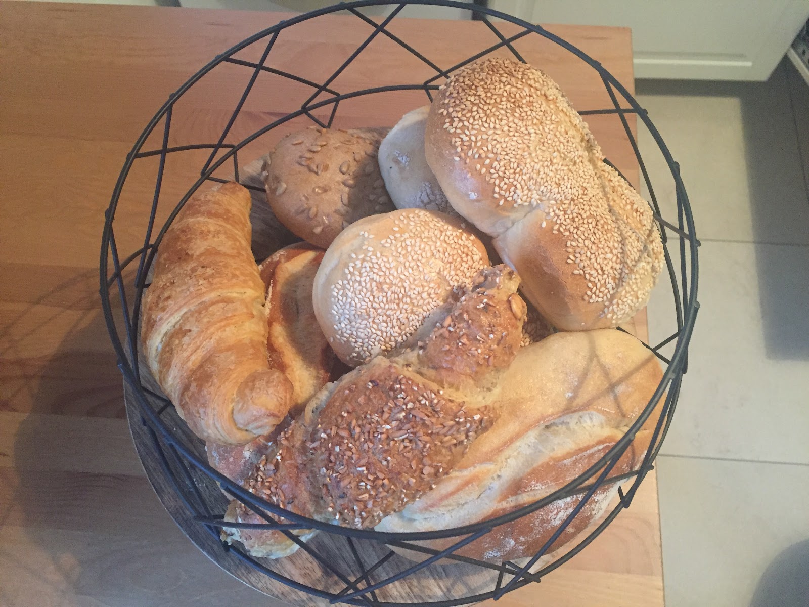 Körbchen mit frischen Brötchen und Croissants